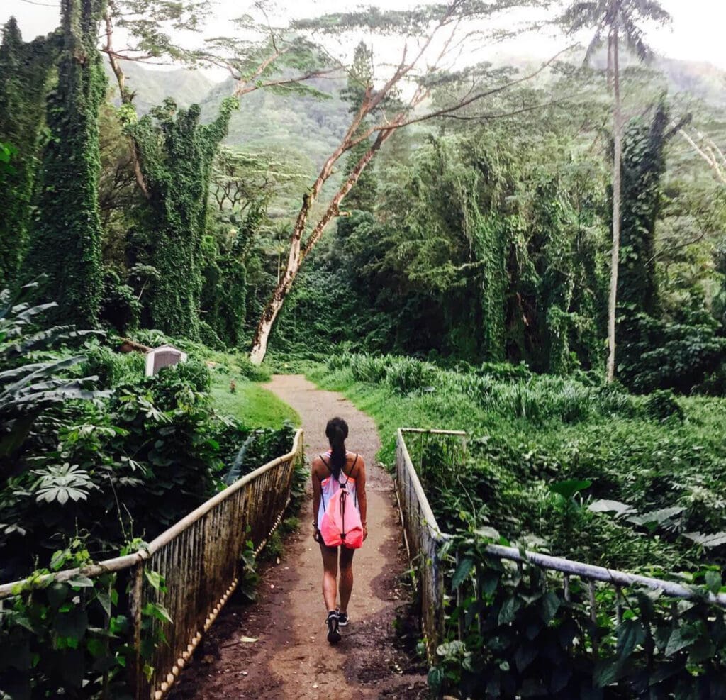 Girl walking along a trail through a tropical green rainforest