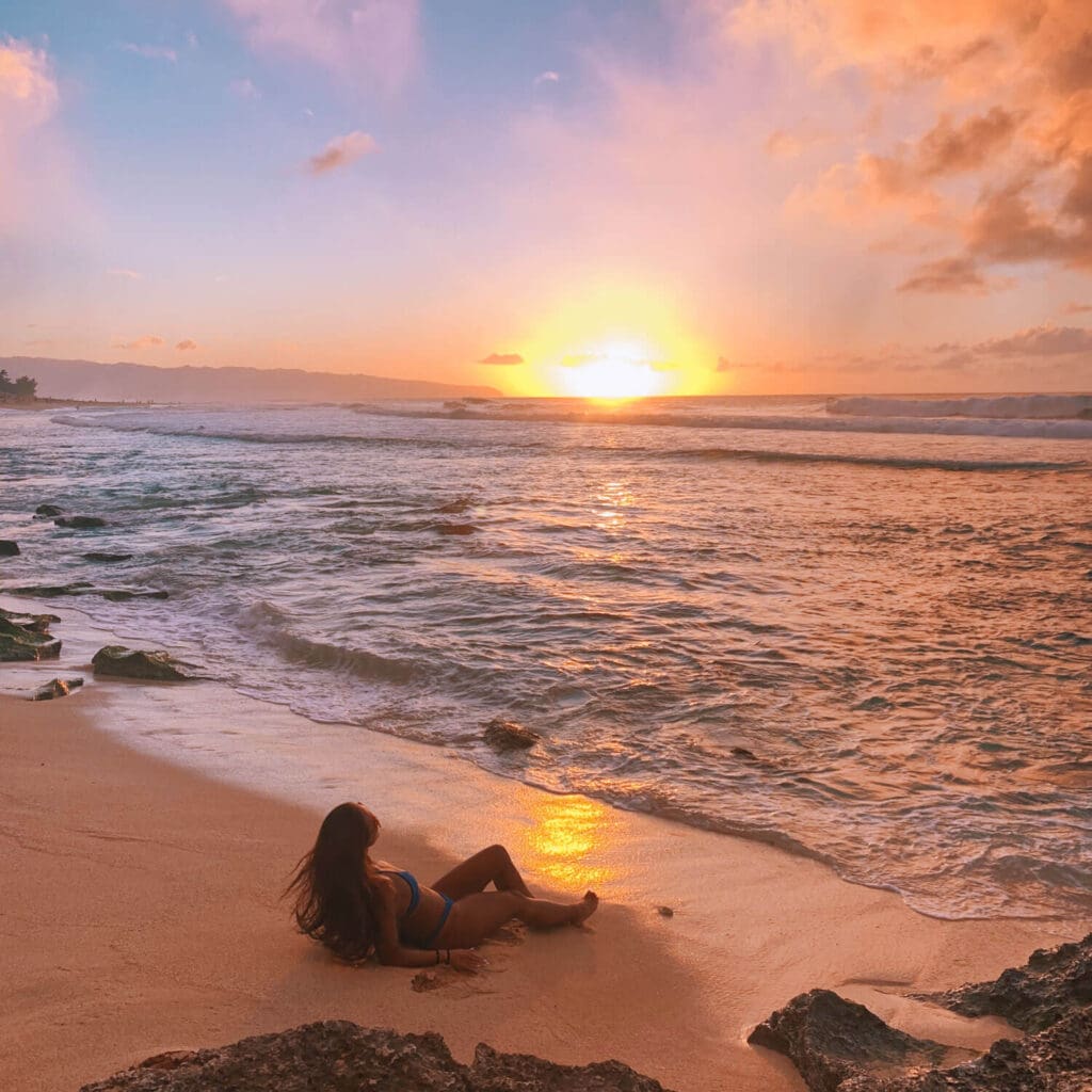 Girl laying on the beach during sunset in Oahu
