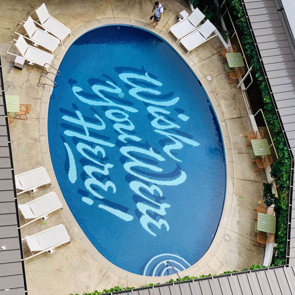 Surfjack Waikiki hotel pool with wish you were here text on the bottom
