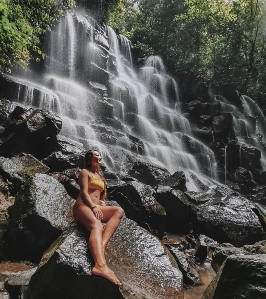 Girl sitting at the bottom of Kanto Lampo Waterfall