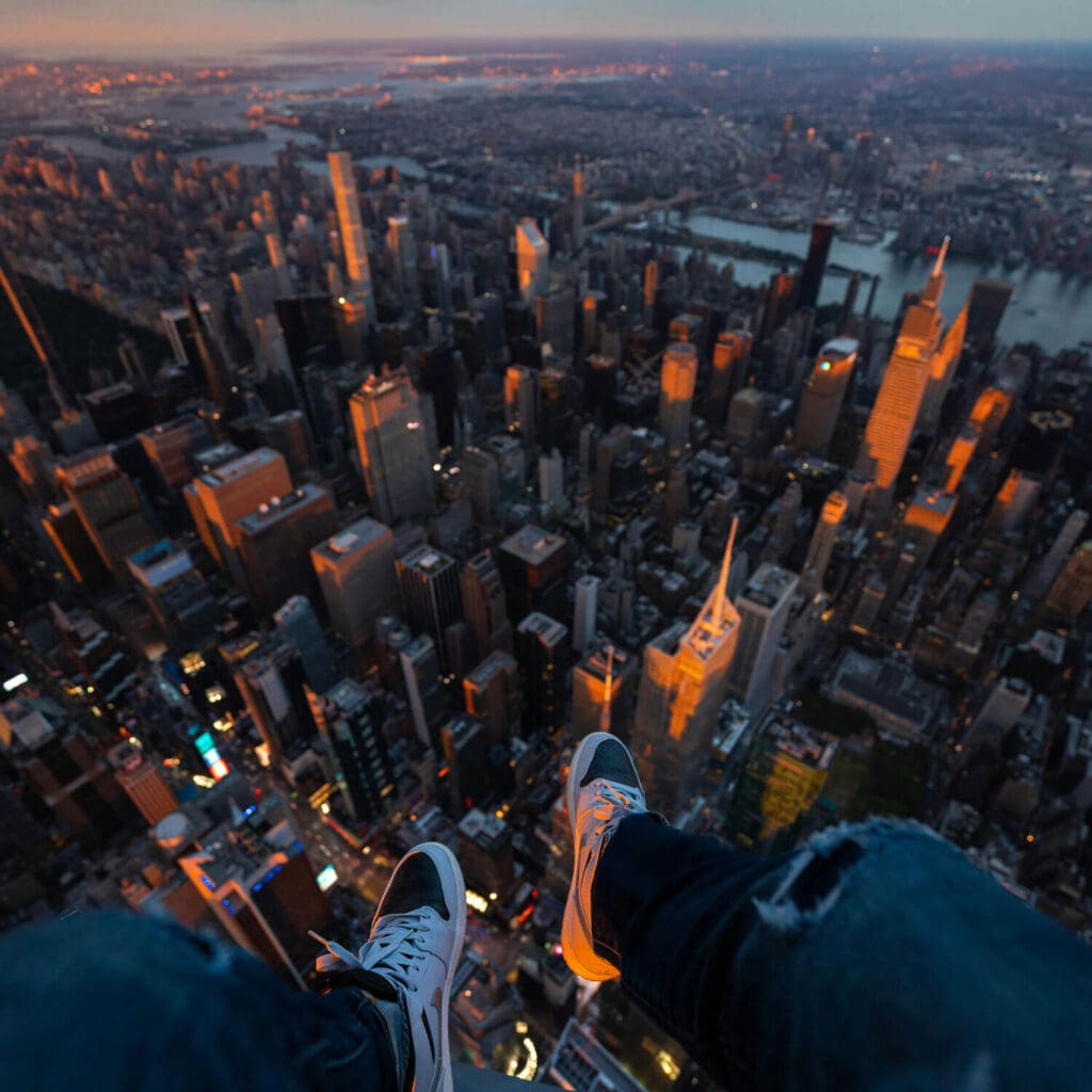 Feet dangling over Manhattan in helicopter at night time